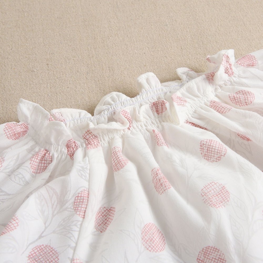 vestido de niña blanco con estampado en tonos rosas y volante inferior