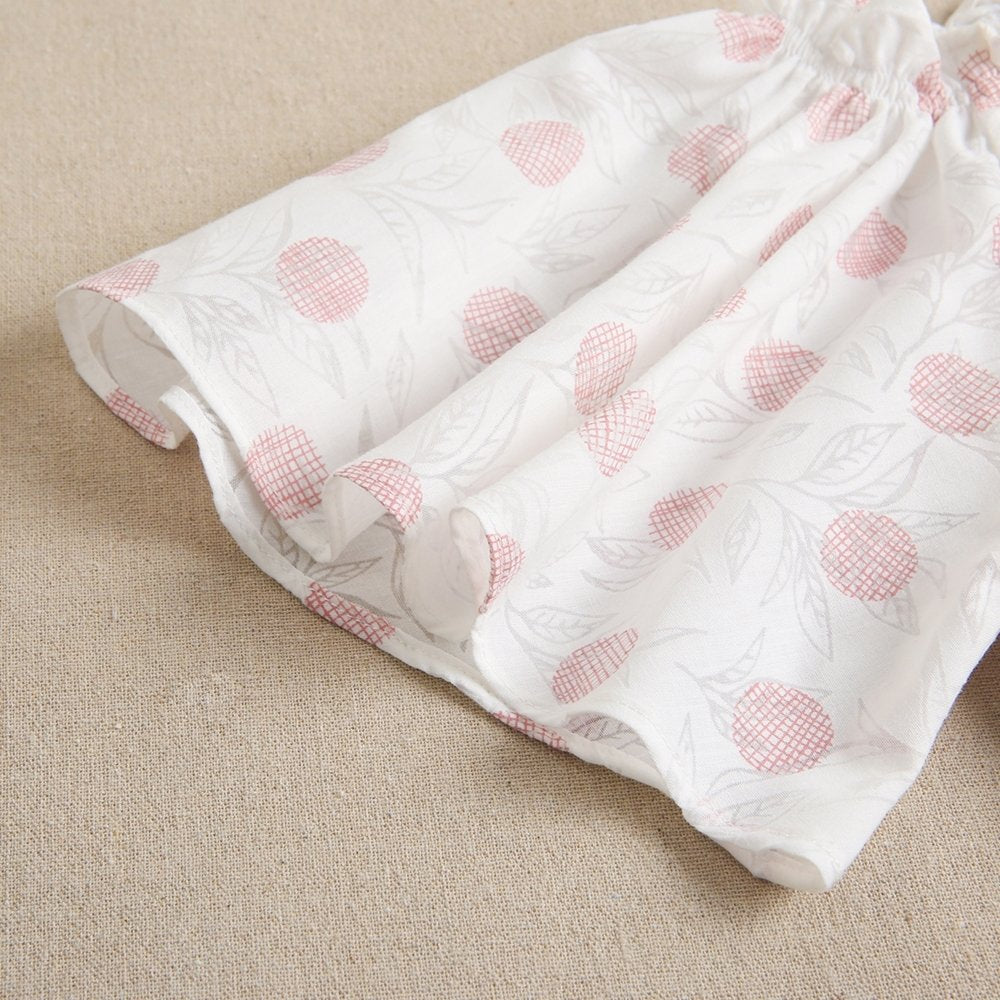 vestido de niña blanco con estampado en tonos rosas y volante inferior