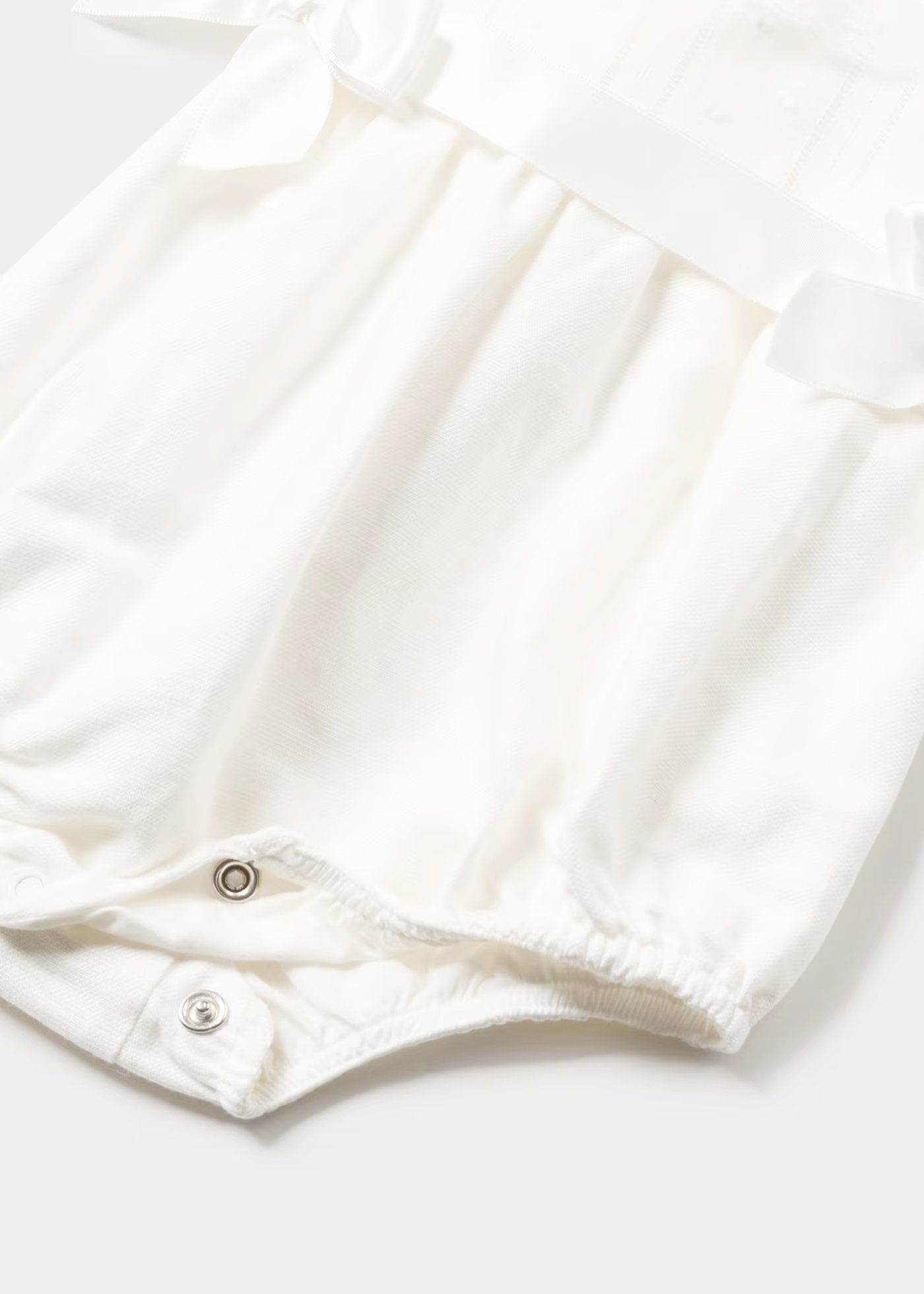 pelele color nata con moños en los laterales