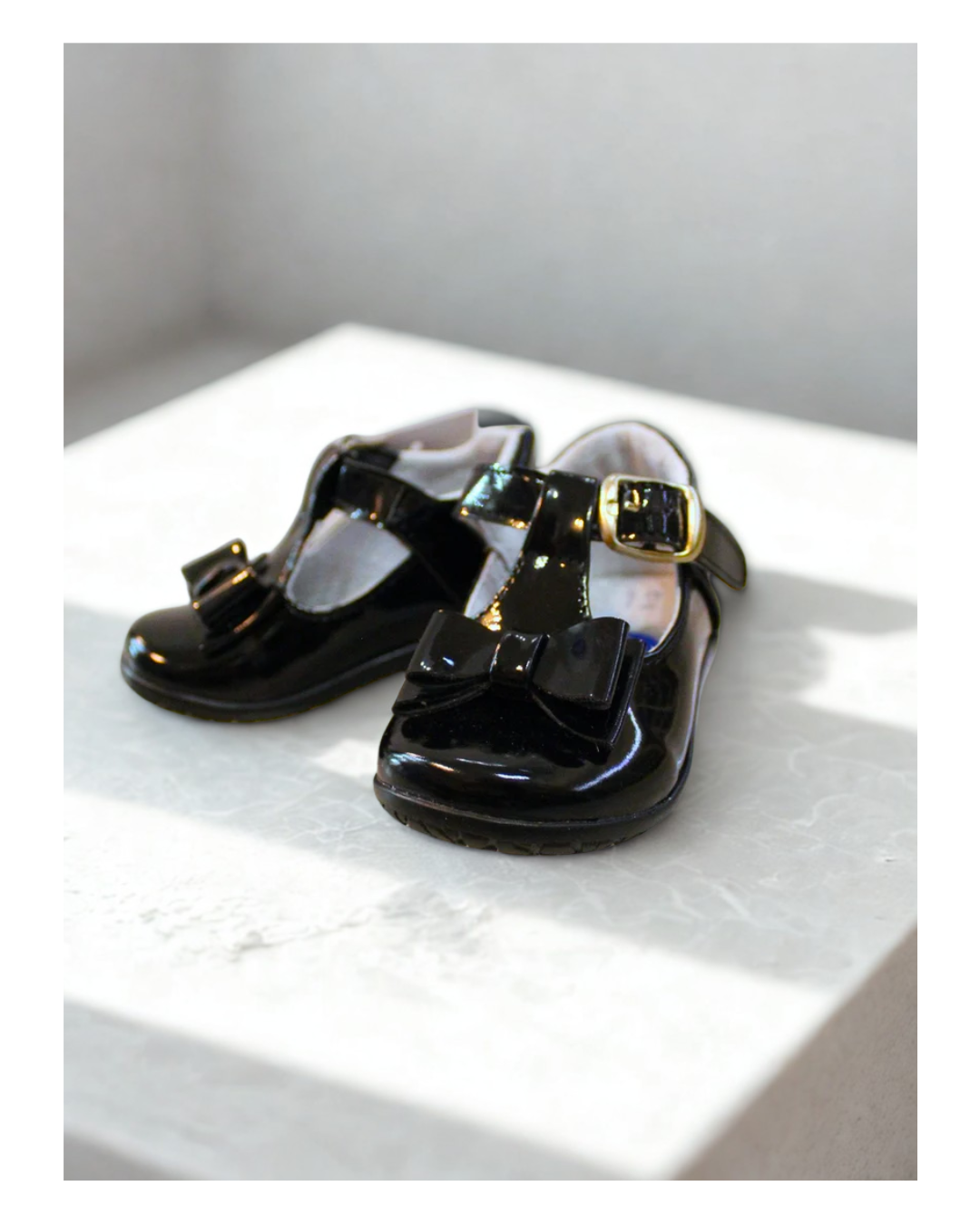 zapato charol color negro con hebilla oro y moño