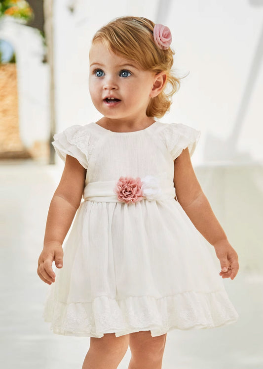 vestido ceremonia con fajin, y olan en la falda color blanco y flor rosa