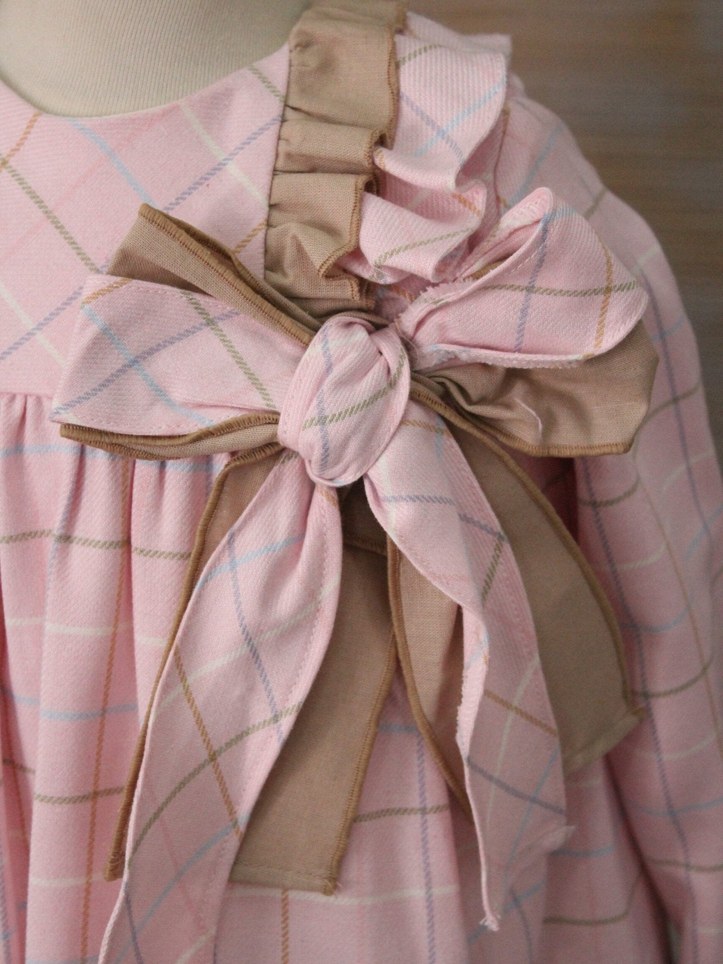 vestido rosa cuadros y olanes lisos, moño en el pecho